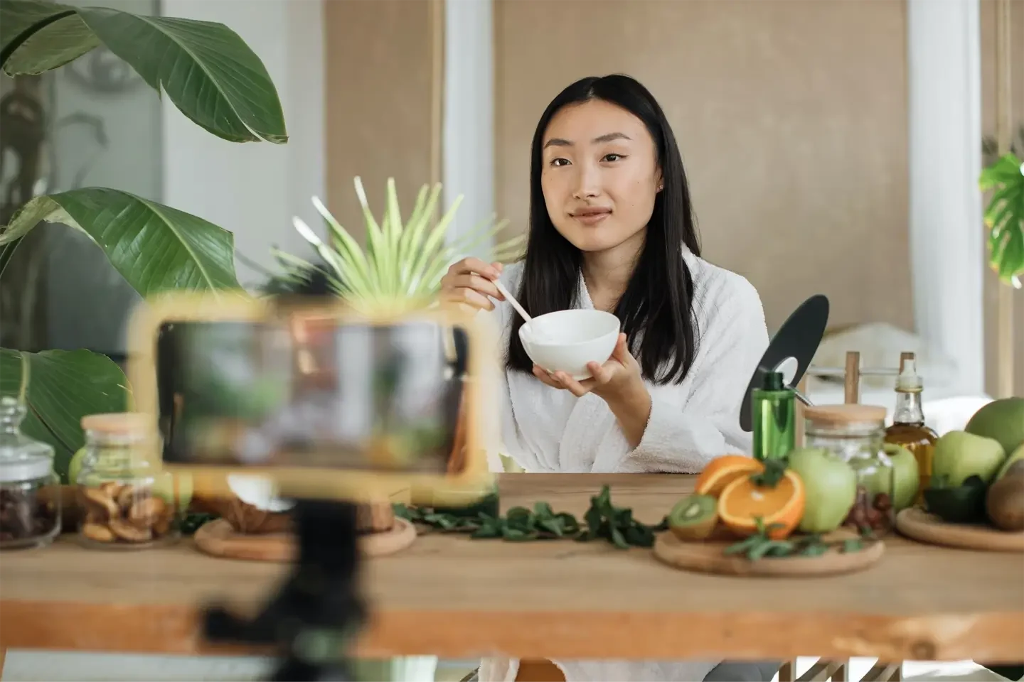 young-asian-woman-blogger-or-content-creator-in-white-bathrobe-preparing-cream-